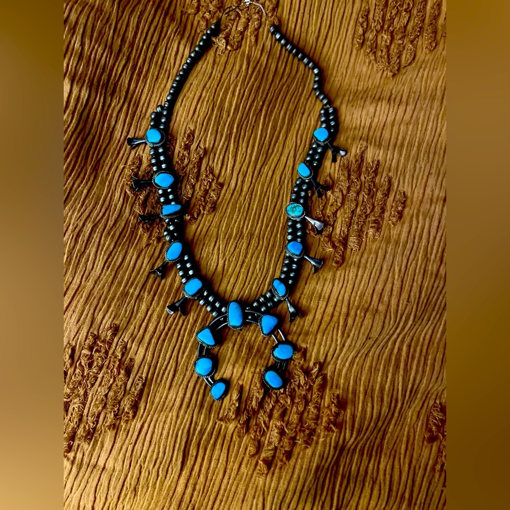 This is a vintage squash blossom necklace stamped silver and real turquoise.